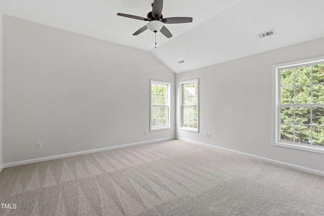 carpeted spare room with baseboards, healthy amount of natural light, and vaulted ceiling