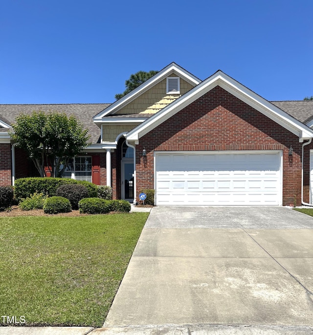 view of front of property featuring a garage, driveway, a front lawn, brick siding, and roof with shingles