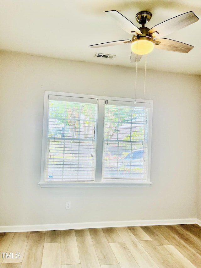 empty room featuring light wood-style floors, ceiling fan, and baseboards