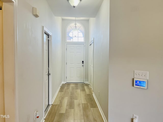 doorway to outside featuring light wood-style floors and baseboards