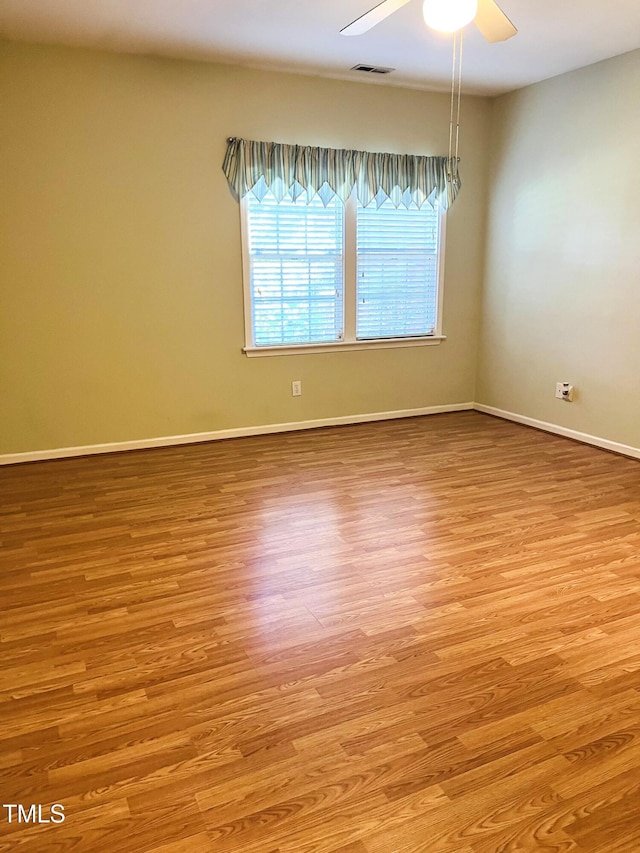 unfurnished room with light wood-type flooring, ceiling fan, and baseboards