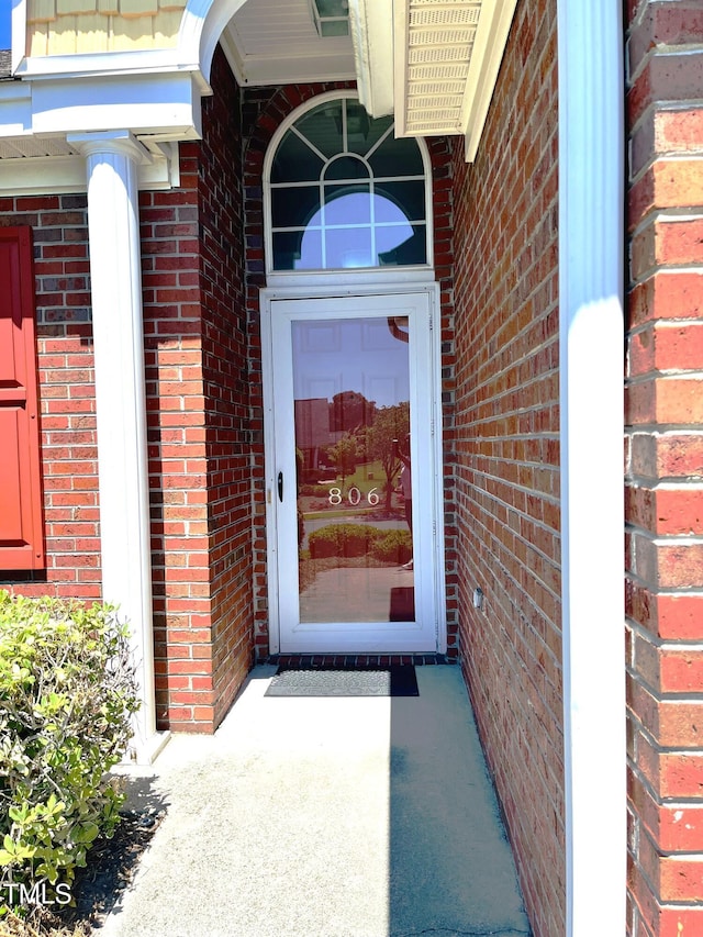 doorway to property with brick siding
