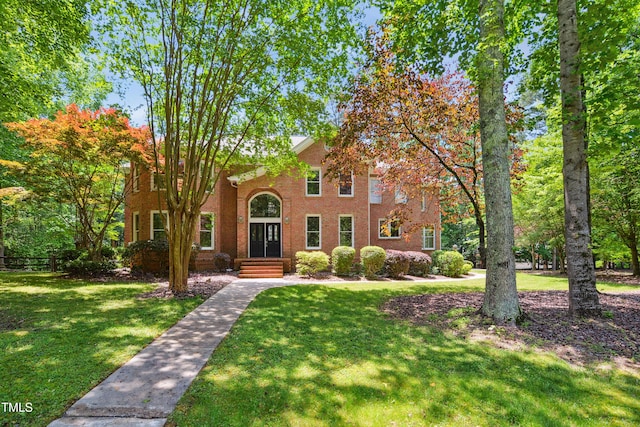 view of front facade with a front lawn and brick siding