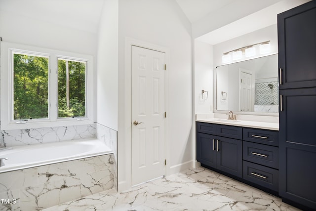 bathroom with vanity, a bath, marble finish flooring, lofted ceiling, and baseboards