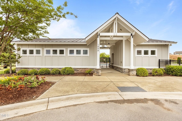 825 Abbyberry Dr, Wake Forest, NC 27587 - view of front of property featuring board and batten siding, metal roof, fence, and stone siding