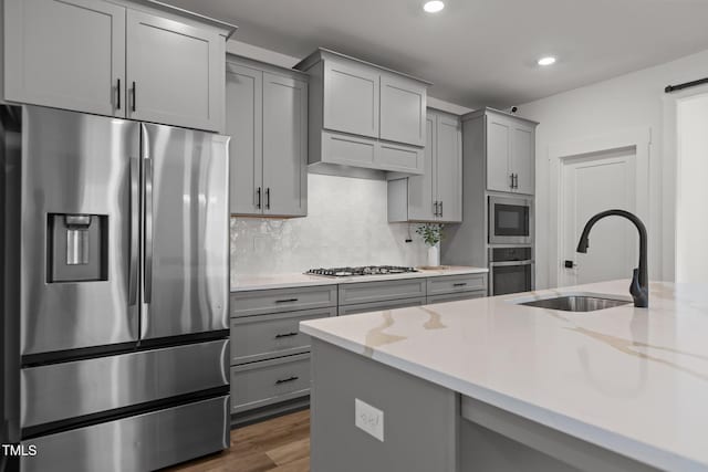 825 Abbyberry Dr, Wake Forest, NC 27587 - kitchen with stainless steel appliances, gray cabinetry, a sink, recessed lighting, and light stone countertops