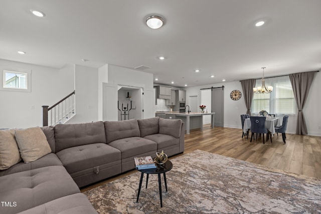 825 Abbyberry Dr, Wake Forest, NC 27587 - living room featuring a barn door, light wood-style floors, a chandelier, recessed lighting, and baseboards