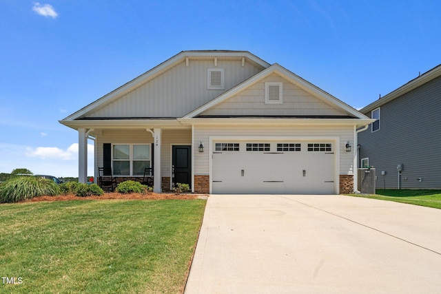 craftsman house featuring stone siding, a front yard, an attached garage, concrete driveway, and a porch
