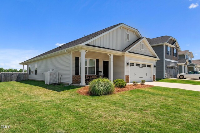 view of front of property with covered porch, driveway, an attached garage, a shingled roof, and stone siding