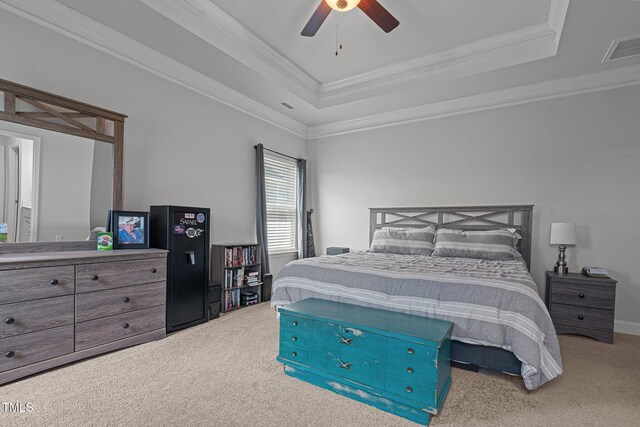 carpeted bedroom with a raised ceiling, crown molding, and a ceiling fan