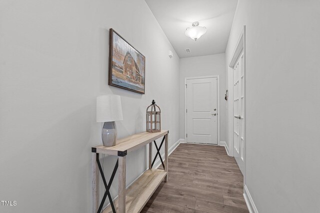 doorway featuring dark wood-type flooring and baseboards