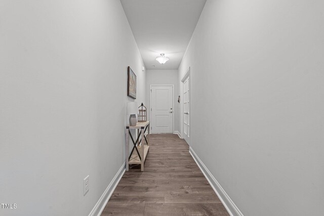 hall with wood finished floors and baseboards