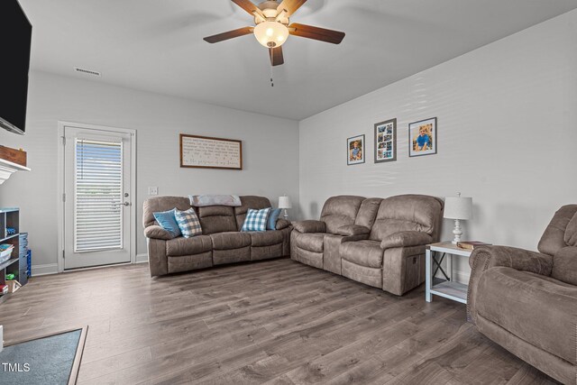 living area featuring a ceiling fan and wood finished floors