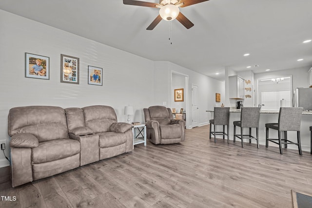 living area featuring a ceiling fan, light wood-type flooring, recessed lighting, and baseboards
