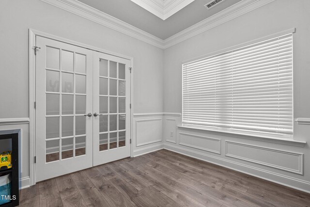unfurnished room featuring french doors, dark wood-type flooring, crown molding, and wainscoting