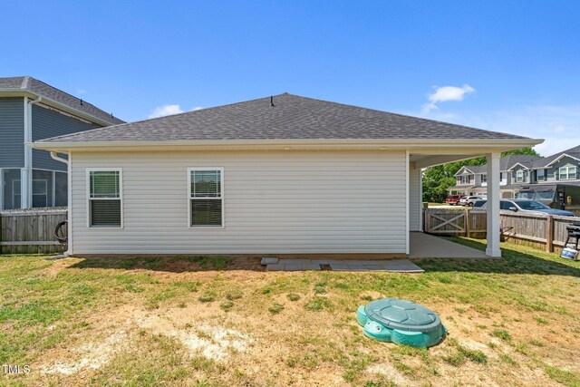 back of property with a shingled roof and a patio area