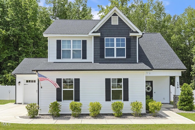 view of front of house with concrete driveway, a shingled roof, fence, and an attached garage