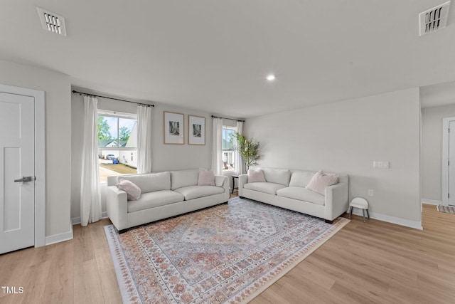 living area featuring light wood-style flooring, plenty of natural light, baseboards, and recessed lighting