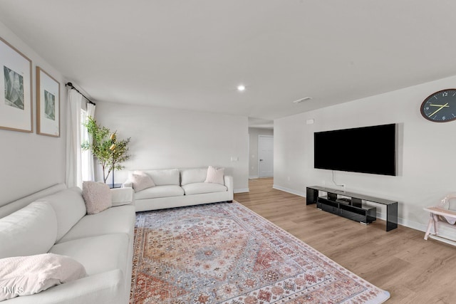 living area with light wood-style floors, baseboards, and recessed lighting