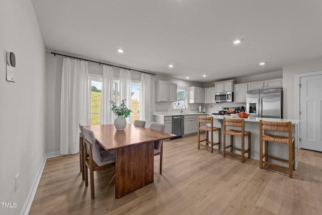 dining room with recessed lighting, light wood-type flooring, and baseboards