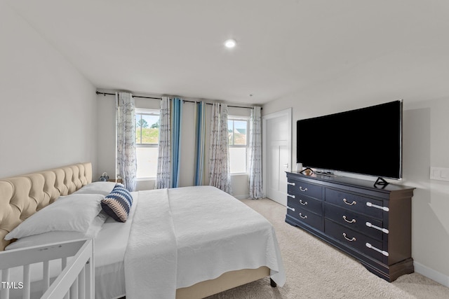 bedroom featuring light carpet and baseboards