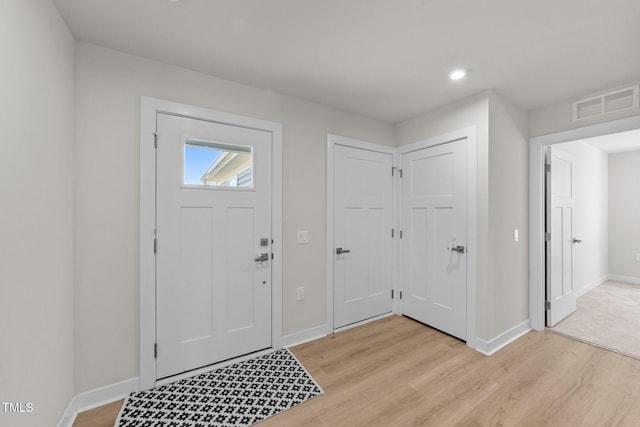 foyer entrance with light wood-style flooring, baseboards, and recessed lighting