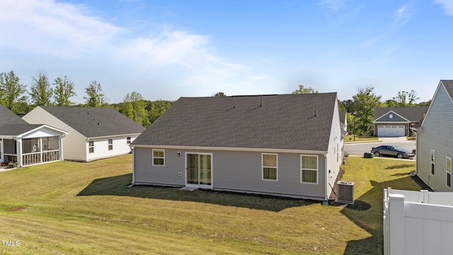 rear view of house with central AC and a shingled roof