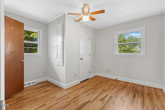 unfurnished bedroom featuring ornamental molding, light wood-style flooring, baseboards, and a ceiling fan