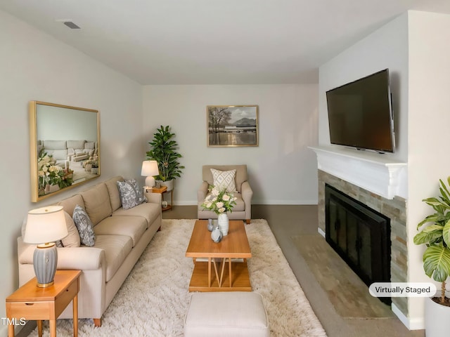 living room featuring a glass covered fireplace, baseboards, and wood finished floors
