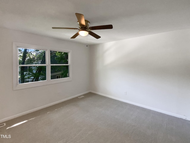 empty room with carpet flooring, a ceiling fan, and baseboards