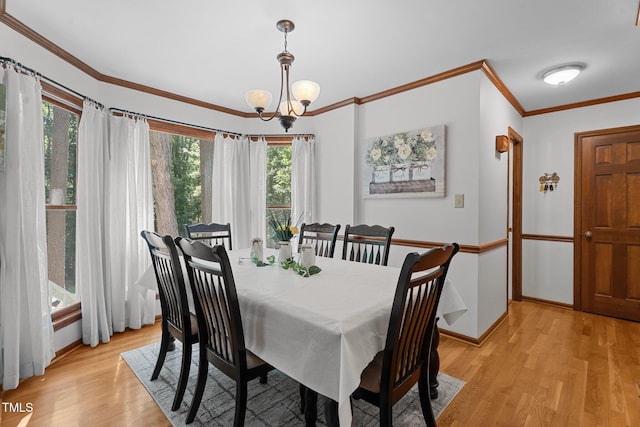 6517 Hidden Pond Rd, Wendell, NC 27591 - dining space with a chandelier, light wood-type flooring, healthy amount of natural light, baseboards, and crown molding