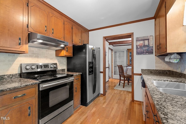 6517 Hidden Pond Rd, Wendell, NC 27591 - kitchen featuring stainless steel appliances, under cabinet range hood, brown cabinetry, light wood-style floors, and decorative backsplash