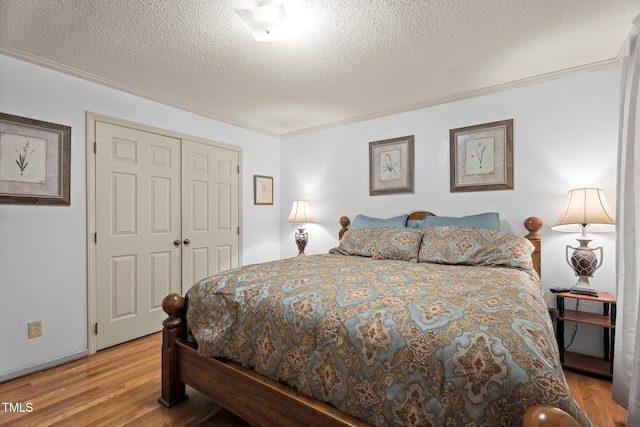 6517 Hidden Pond Rd, Wendell, NC 27591 - bedroom with light wood finished floors, a textured ceiling, a closet, and ornamental molding