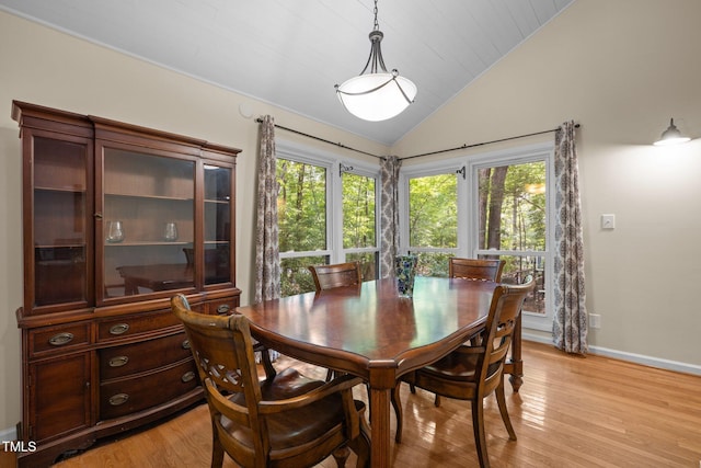 dining area featuring vaulted ceiling, healthy amount of natural light, light wood-style floors, and baseboards