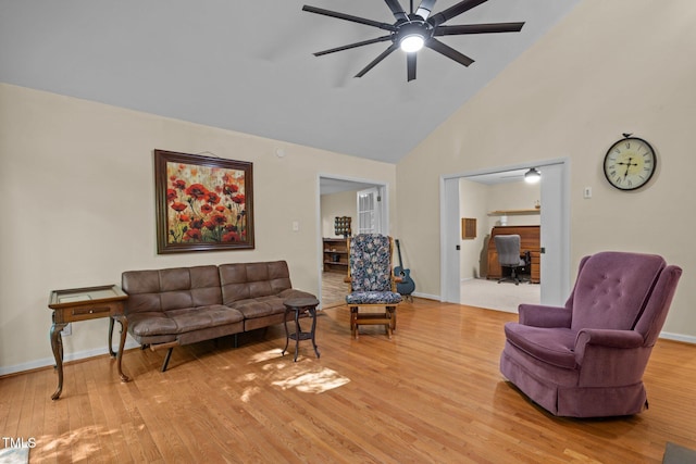 living area featuring high vaulted ceiling, light wood-type flooring, a ceiling fan, baseboards, and a desk