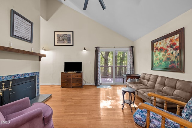 living area featuring light wood finished floors, high vaulted ceiling, and a ceiling fan