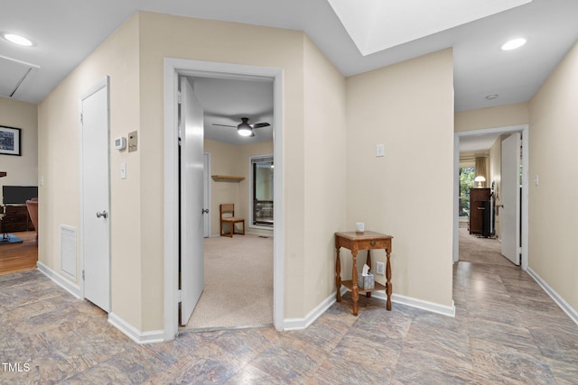 corridor featuring baseboards, stone finish flooring, and recessed lighting
