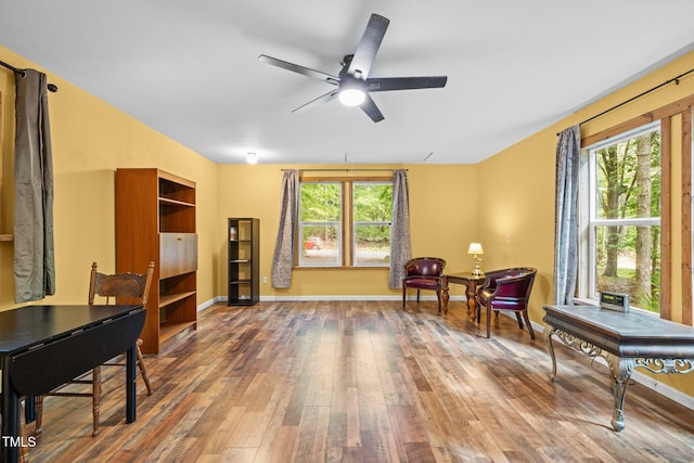 sitting room featuring healthy amount of natural light, ceiling fan, hardwood / wood-style floors, and baseboards
