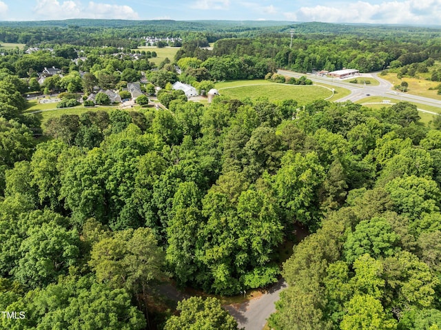 aerial view of property and surrounding area featuring a heavily wooded area