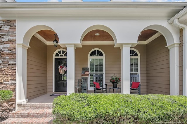 doorway to property featuring covered porch and stone siding