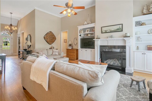 42 Skipping Water Dr, Spring Lake, NC 28390 - living room featuring ornamental molding, light wood-style floors, a chandelier, a fireplace with flush hearth, and ceiling fan