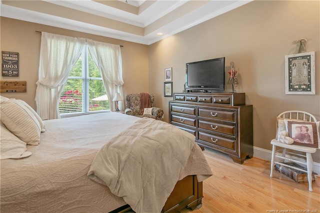 bedroom featuring crown molding, light wood-type flooring, baseboards, a raised ceiling, and recessed lighting