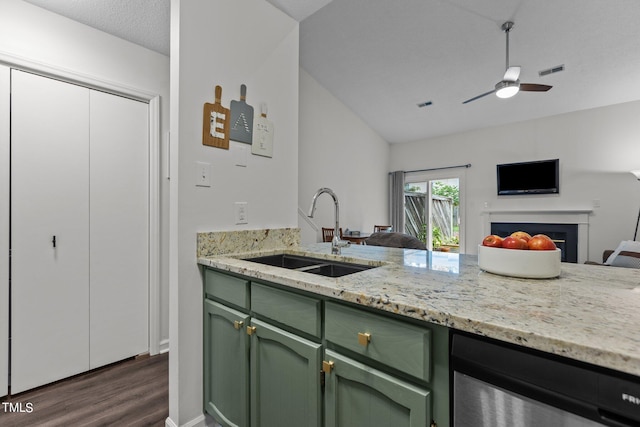 kitchen featuring green cabinetry, a sink, dark wood finished floors, and a fireplace