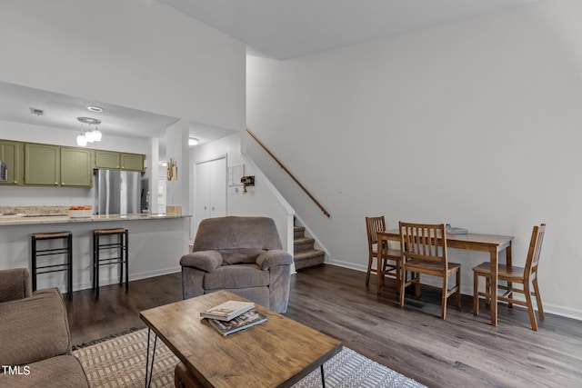 living area featuring wood finished floors, stairs, and baseboards