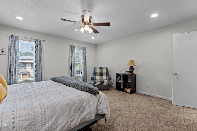 carpeted bedroom with multiple windows, recessed lighting, a ceiling fan, a textured ceiling, and baseboards