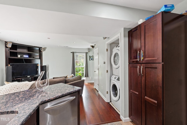 laundry room with stacked washer / dryer, wood finished floors, baseboards, and recessed lighting