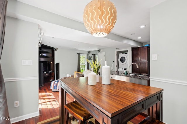 dining area featuring stacked washer / dryer, recessed lighting, and wood finished floors