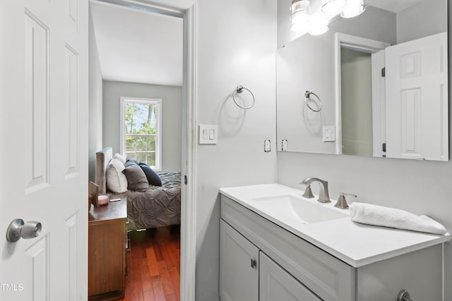 bathroom with hardwood / wood-style flooring, vanity, and ensuite bathroom