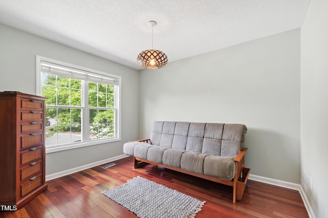 sitting room featuring a textured ceiling, hardwood / wood-style flooring, and baseboards