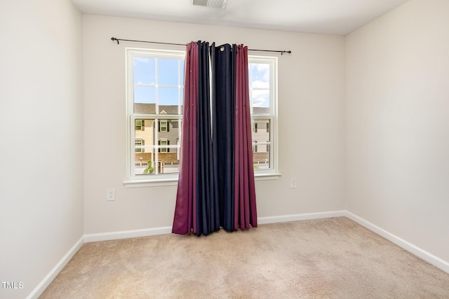 carpeted empty room with plenty of natural light and baseboards